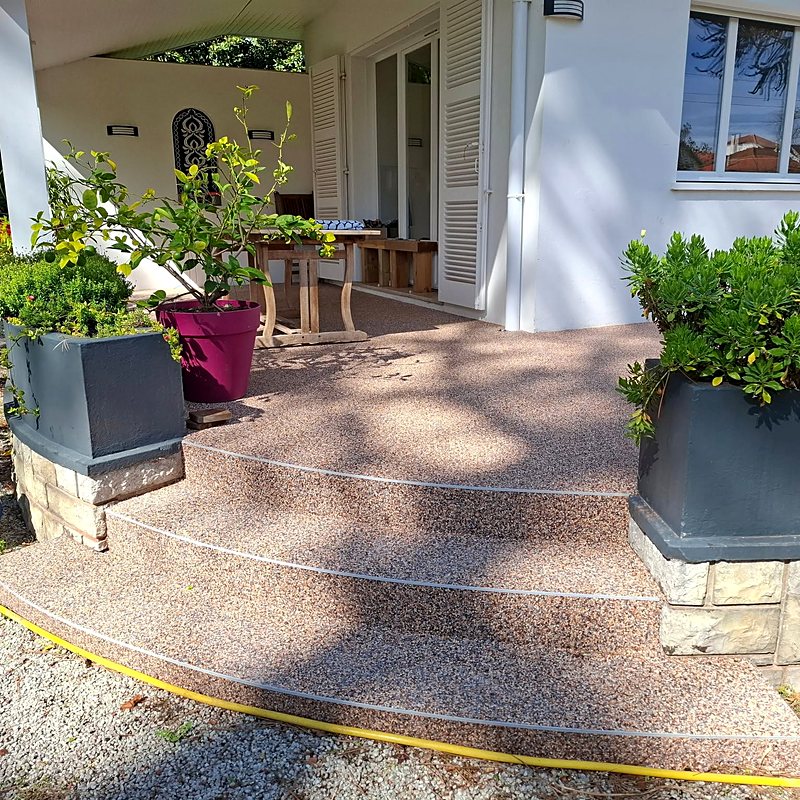 Perron et escalier en moquette de pierre, jardinières fleuries
